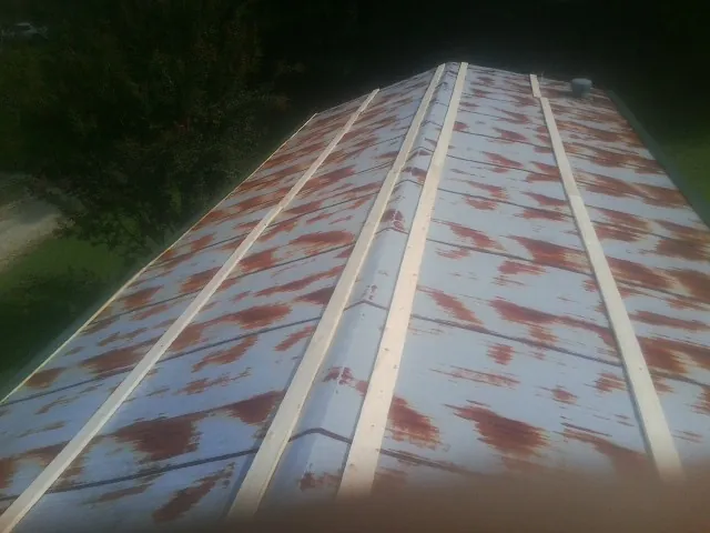 Rusted metal roof panels with new wood purlins before replacement — Storm Damage Roof Repair in Youngstown by Roofing Brothers
