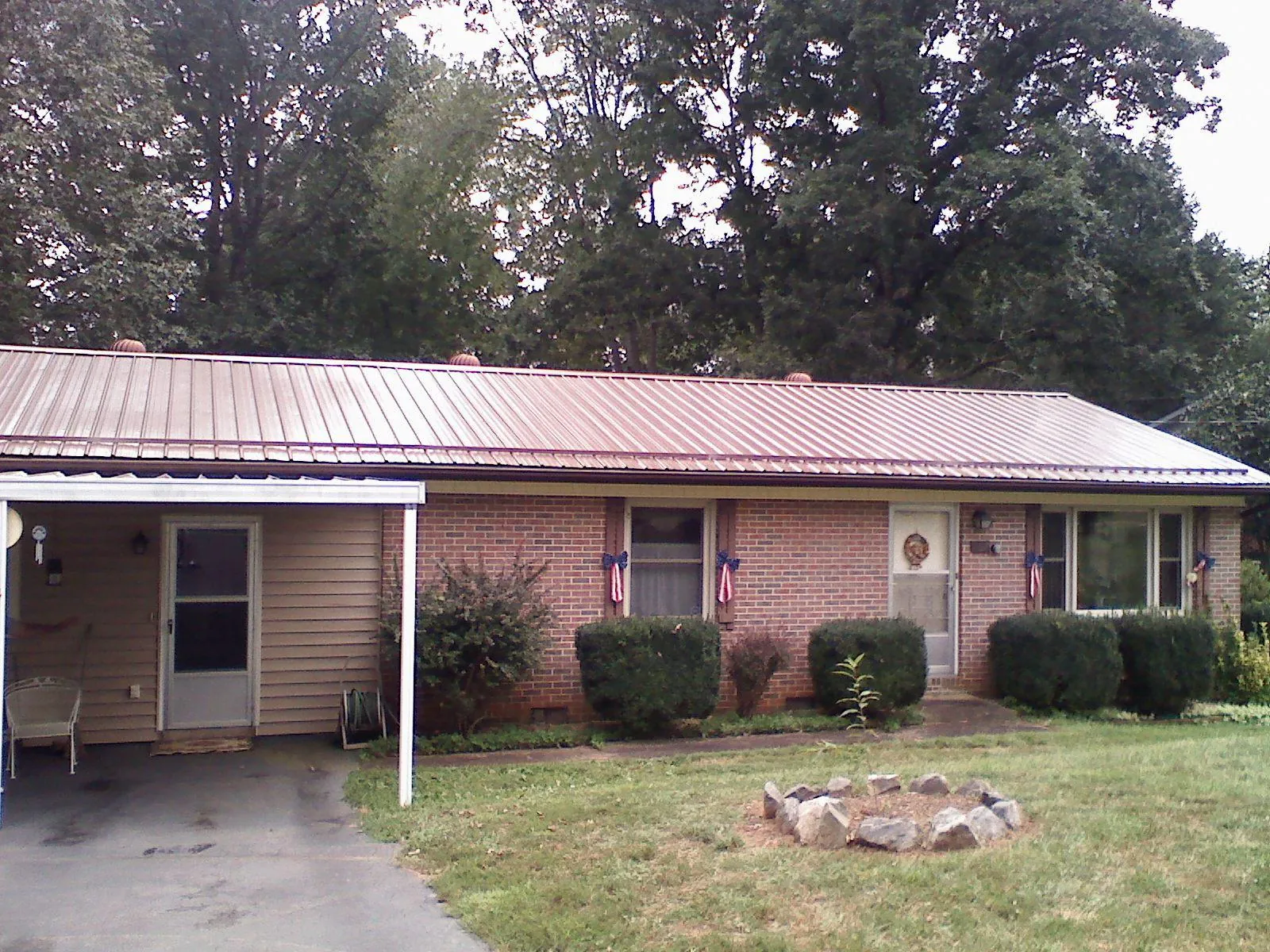 Bronze metal roof and carport on a brick ranch home — Roof Repair work by our crew in Youngstown
